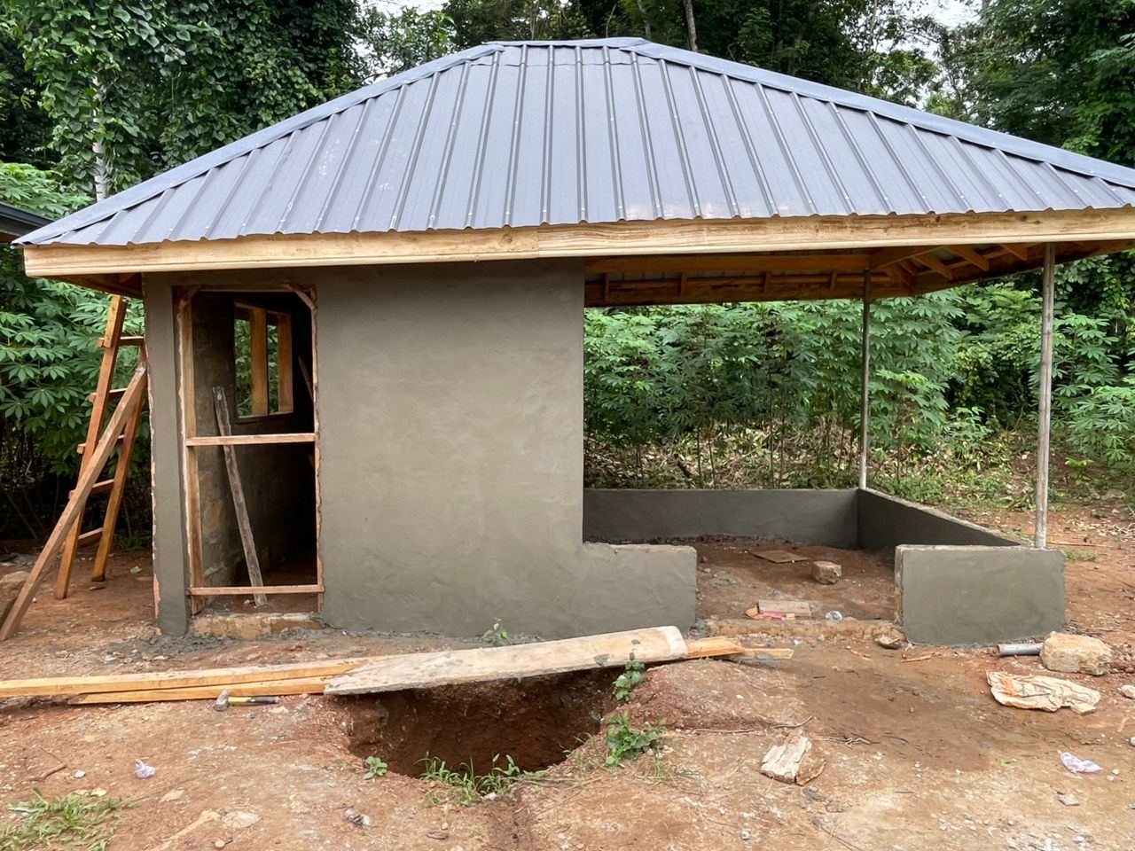 A small outbuilding with its roof sheeted and walls freshly plastered.